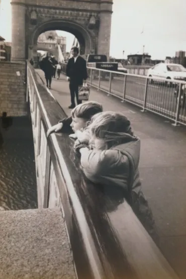 Two children on Tower Bridge looking out to River Thames.