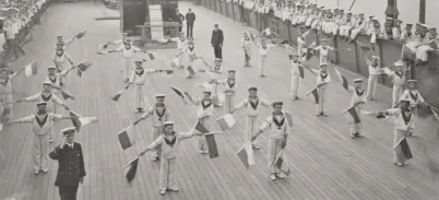 Rows of children on the deck of a ship, holding flags doing semaphore