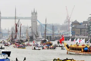 The Queen's Rowbarge and many other vessels of different types on the river Thames with Tower Bridge in the background,