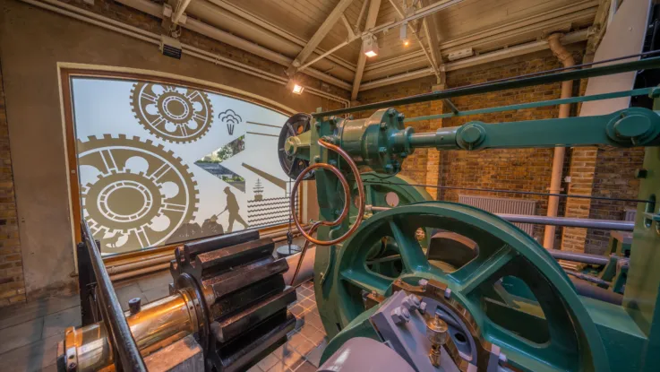 The Engine Rooms at Tower Bridge. Large, teal-coloured machinery is on display.